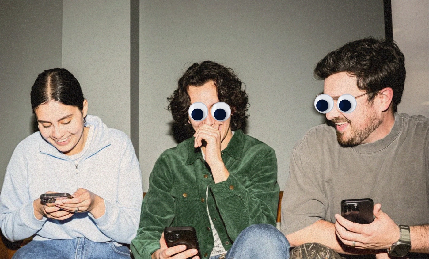 Three friends on a couch laughing at their phones, wearing googly eyes.